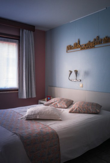 zicht op het groot bed met invallend licht.